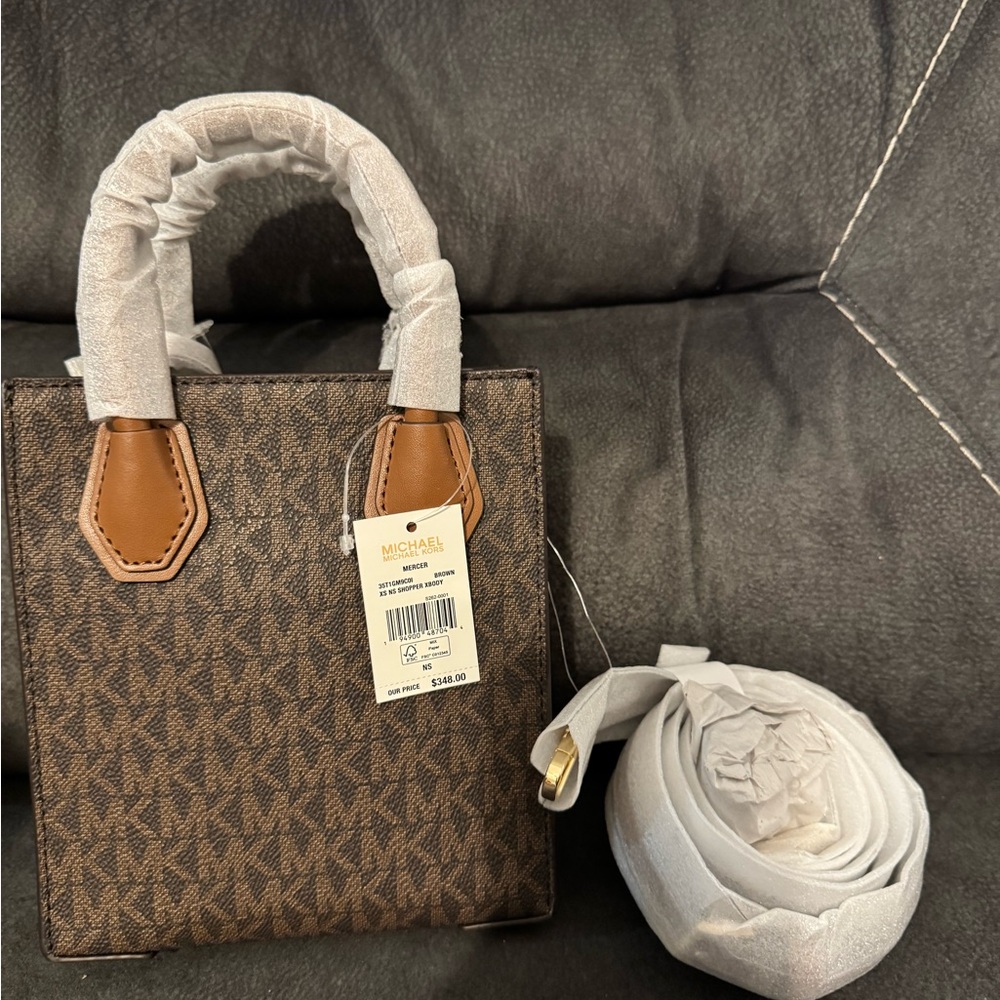 MK Michael Kors Adjustable Signature Canvas Crossbody Bag is brown.